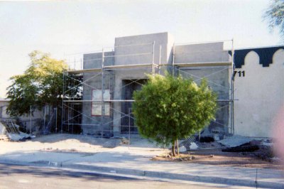 The masjid under construction, walls going up behind scaffolding.