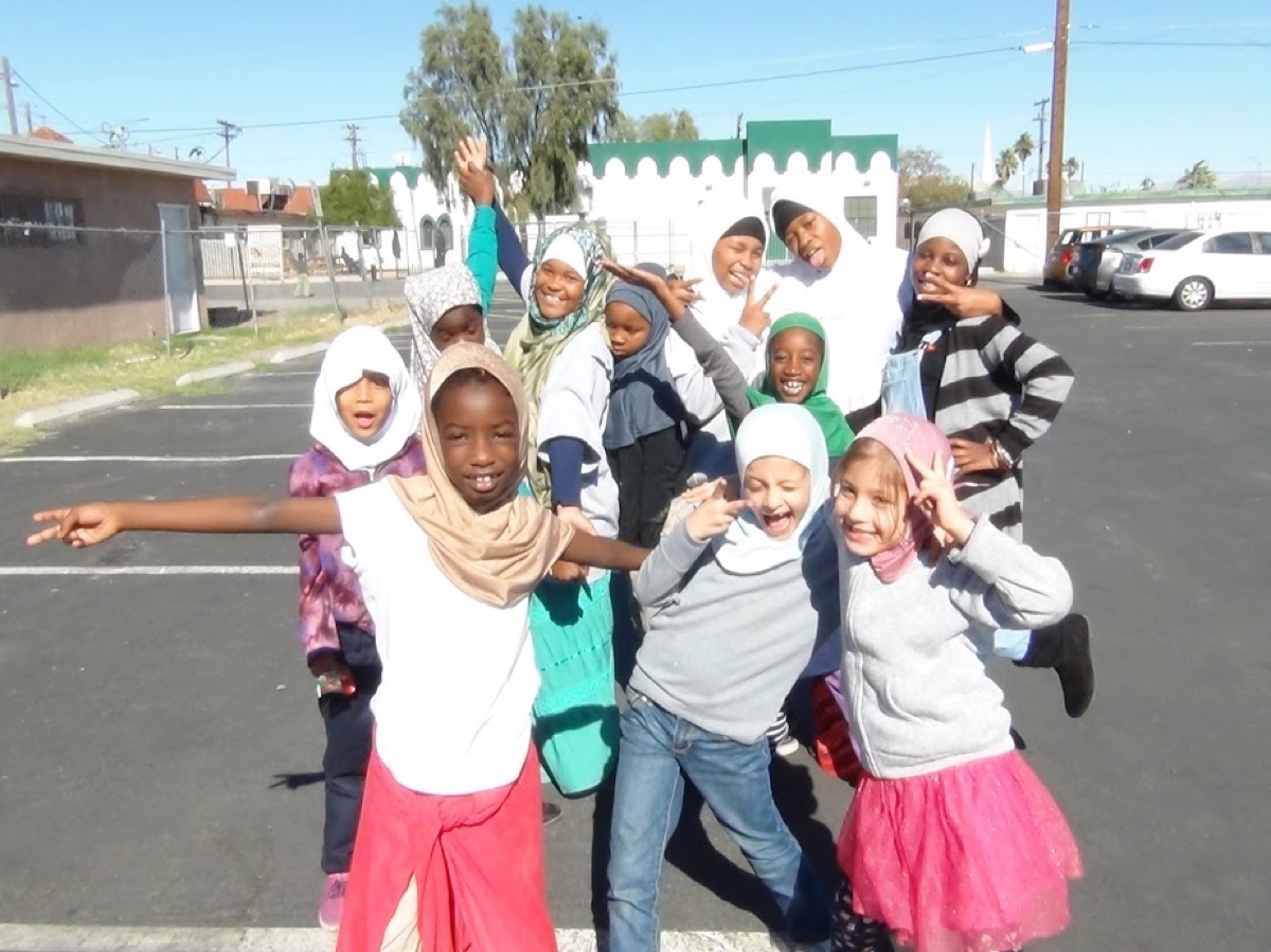 Young Nisaa’s Academy students smiling together outside Masjid As-Sabur.