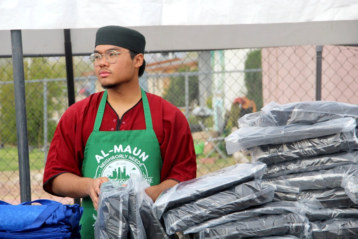 A young Al-Maun volunteer handing out stabilization supplies at a distribution.