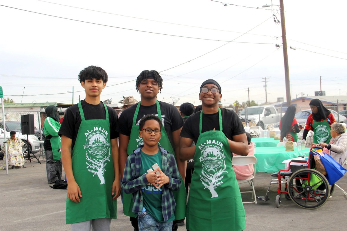 Young Al-Maun volunteers in aprons at a community service day.