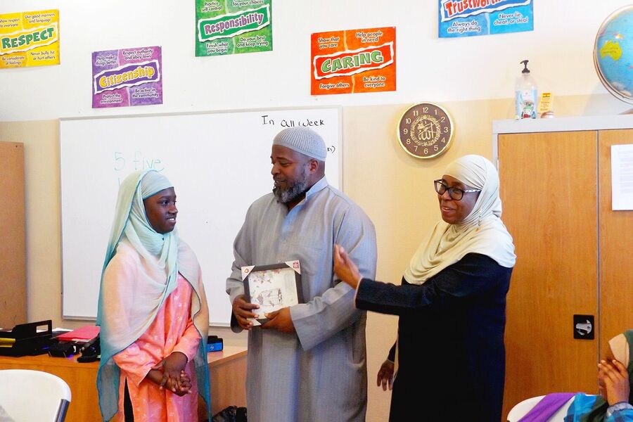 Nisaa&rsquo;s Academy teachers and students in a classroom with character-value posters on the wall.